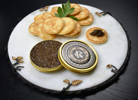 caivar on mini blinis and a cup of caviar 
